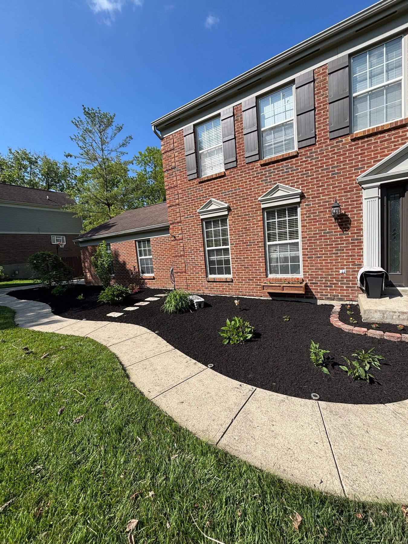 Residential brick house with refreshed landscape beds and dark mulch